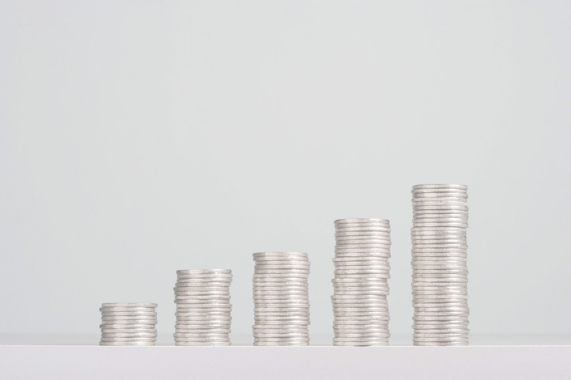 Coins stacked in increasing columns representing savings and financing