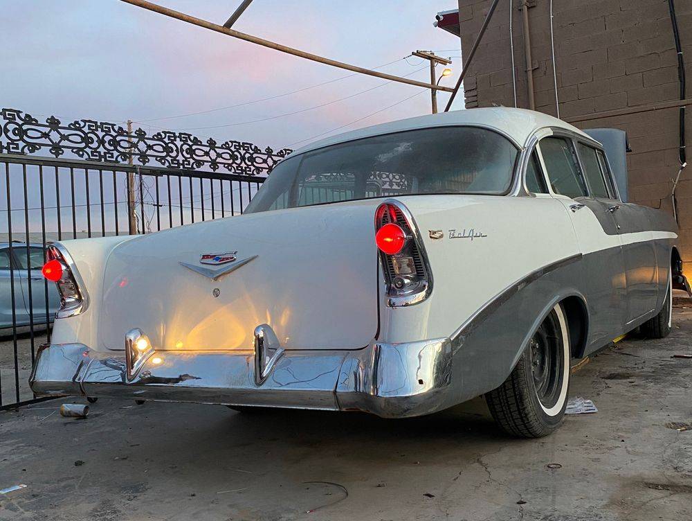 Two-tone 1956 Chevrolet Bel Air parked at the shop at dusk
